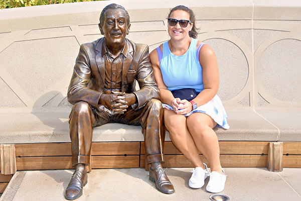 Sam sitting next to a bronze statue.